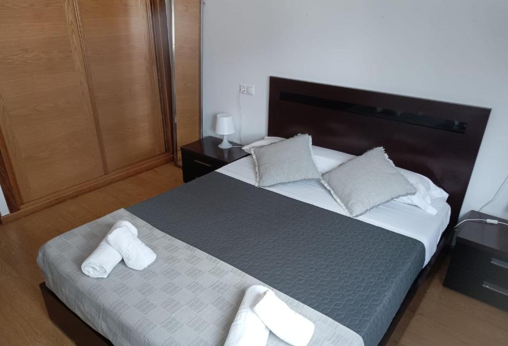 a bedroom with a large bed with white towels on it at Apartamento terra1 in Caldas de Reis