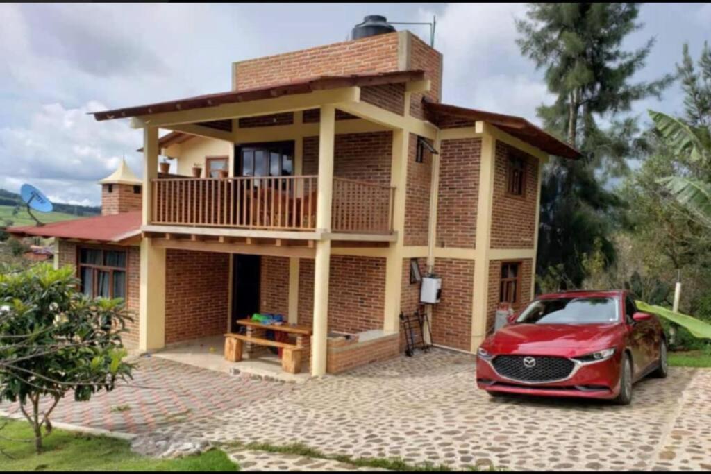 una casa con un coche rojo estacionado frente a ella en Cabaña Rinconcito 10, en Mazamitla