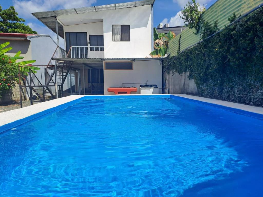 布拉斯利托的住宿－Cabina Privada en Segundo piso con piscina, a 2 min caminando de la playa，一座大蓝色游泳池,位于房子前