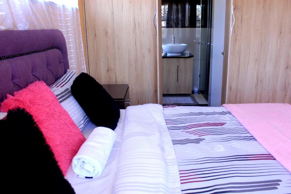 a bed with pink and white towels on it at Joyous Lodges in Cape Town
