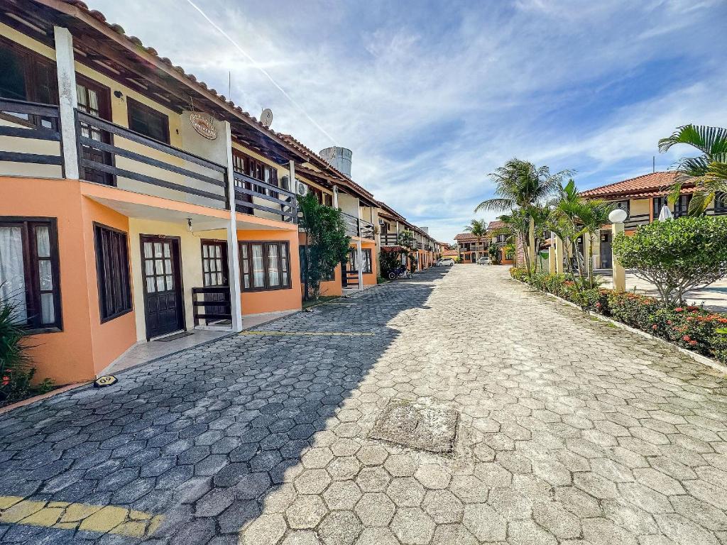 a cobblestone street in a town with buildings at A 200m da praia de Taperapuã Axé Moi 2 suítes, churrasqueira privativa, piscina, sauna portaria 24hrs e internet privativa 300MBPS in Porto Seguro