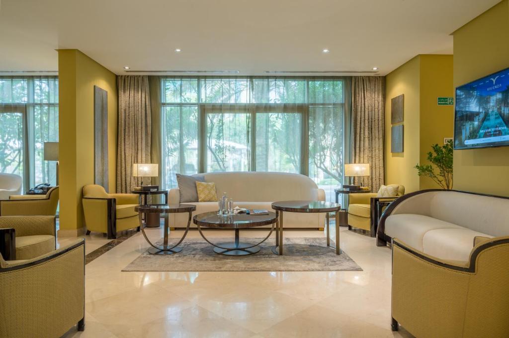 فلل فيفيندا الفندقية غرناطة في الرياض: غرفة معيشة مع أريكة وطاولة