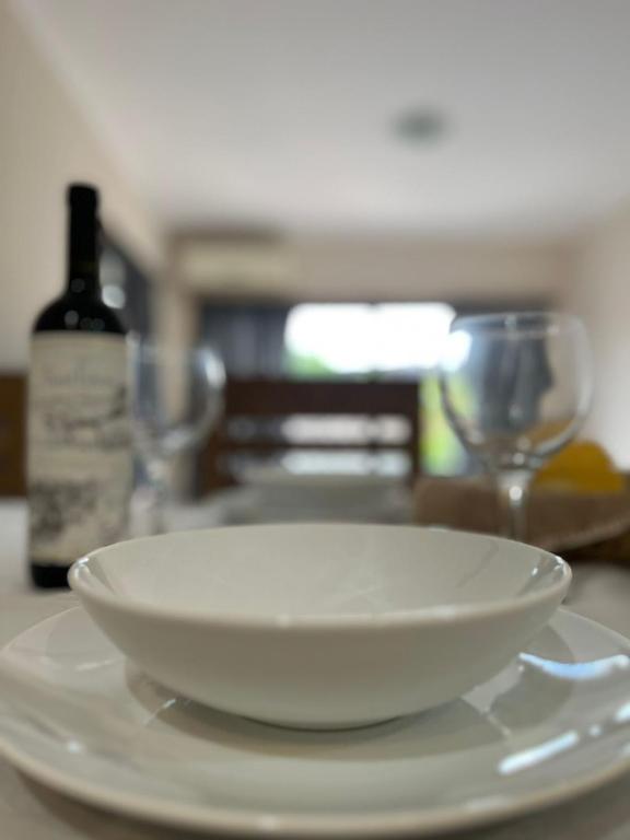 a white plate sitting on a table with a bottle of wine at TempoExtra in Corrientes