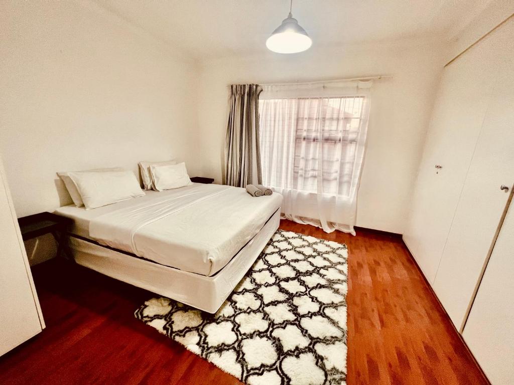 1 dormitorio con cama, ventana y alfombra en Mont Pelaan 40 en Newcastle