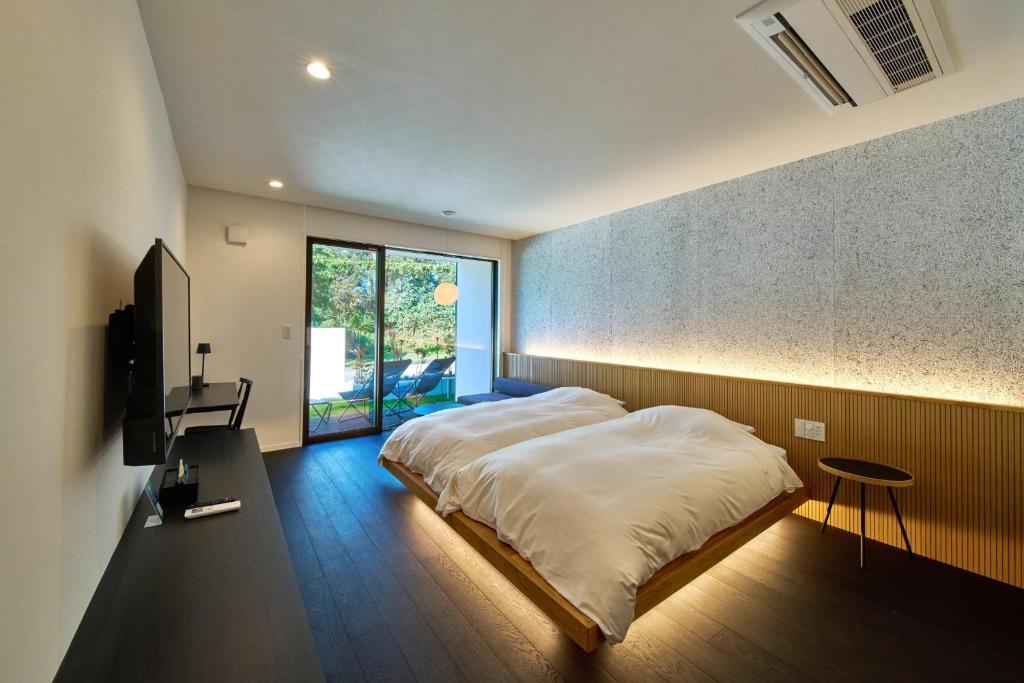 ein Schlafzimmer mit einem großen weißen Bett und einem Fenster in der Unterkunft LUXE TECH VILLA Ashitoku - Vacation STAY 10791v in Akaoki