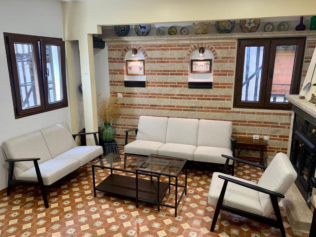 Sala de estar con 2 sofás blancos y mesa de centro en Casa Rural Chorrito 1 en La Alberca