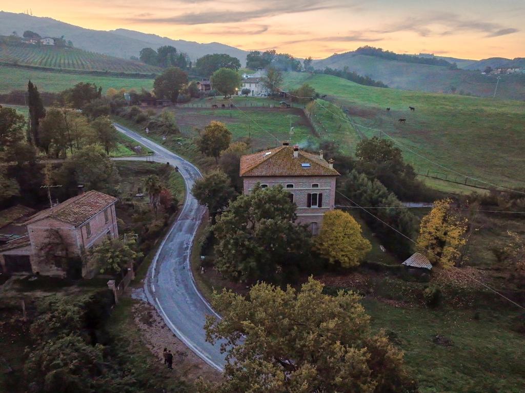 uma estrada sinuosa num campo com uma casa em Palazzo Giulia em Brisighella