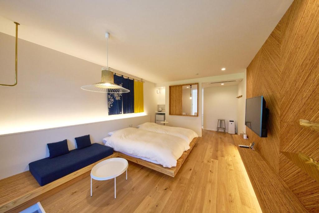 una camera con un grande letto e un divano blu di LUXE TECH VILLA Ashitoku - Vacation STAY 10822v ad Akaogi