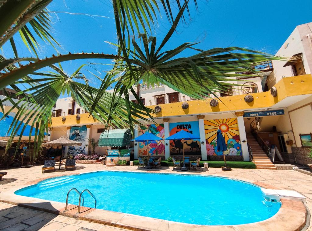 ein Resort mit einem Pool vor einem Gebäude in der Unterkunft Delta Dahab Hotel in Dahab