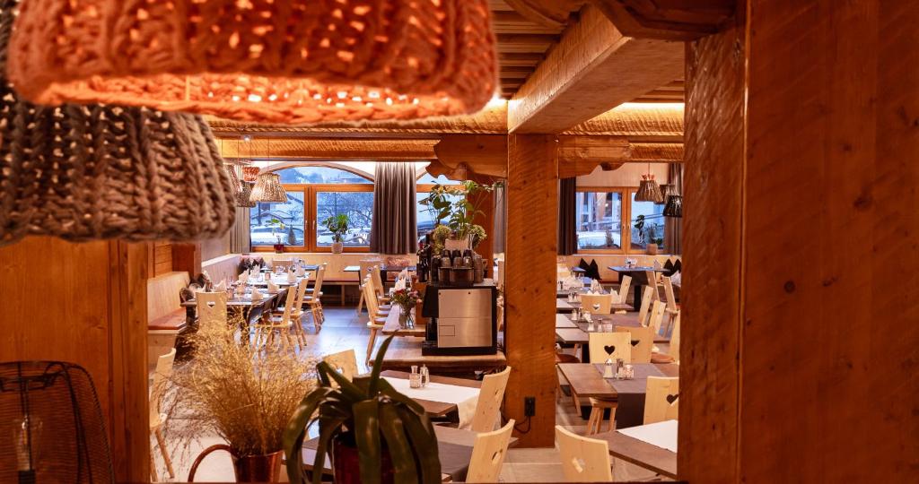 un ristorante con tavoli e sedie in una stanza di Berghotel Basur - Das Schihotel am Arlberg a Flirsch