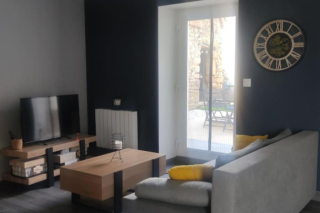 un salon avec un canapé et une télévision dans l'établissement Maison moderne, à Jublains