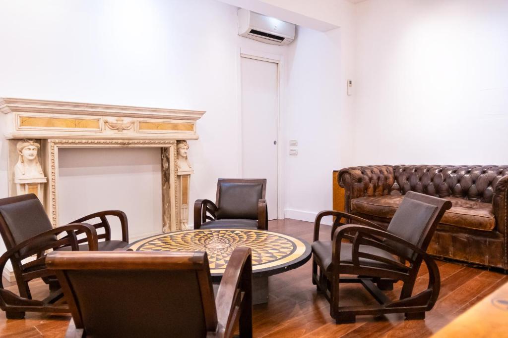 een woonkamer met een bank en een tafel en stoelen bij Charme & Chic San Giacomo in Rome