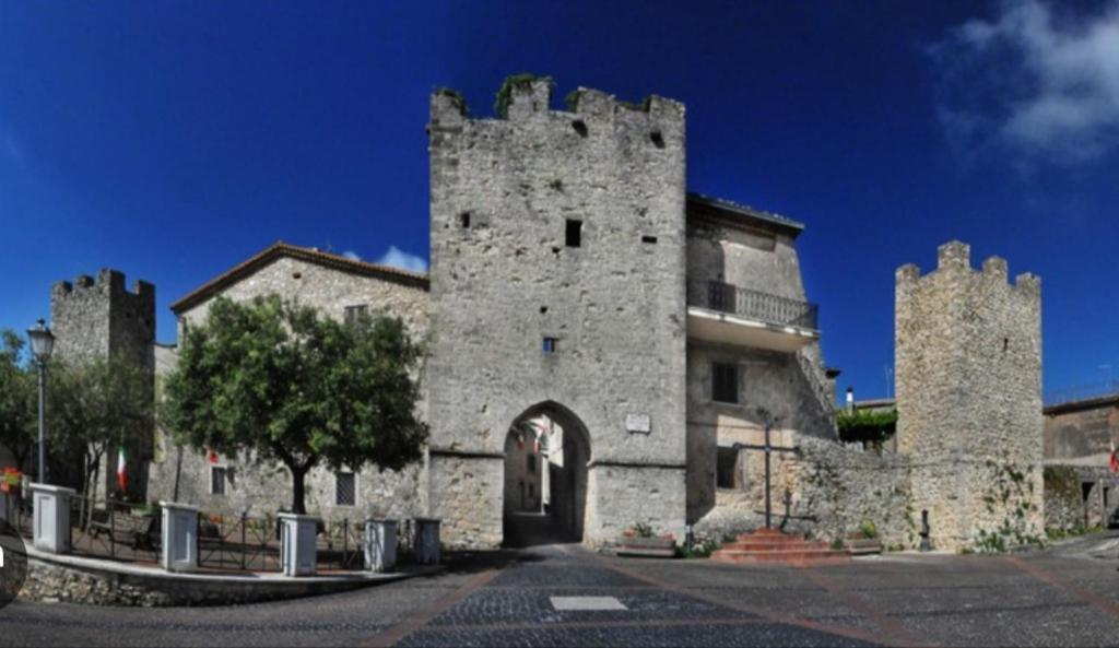 um antigo edifício de pedra com uma grande torre em Martinahouse em Vico nel Lazio