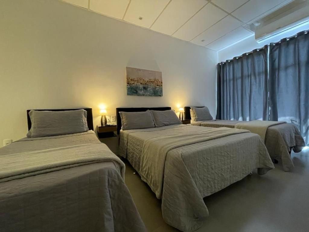 um quarto com 2 camas e uma janela em VILLA BILAC 04 - Amplo Studio próxima à Vila Germânica em Blumenau