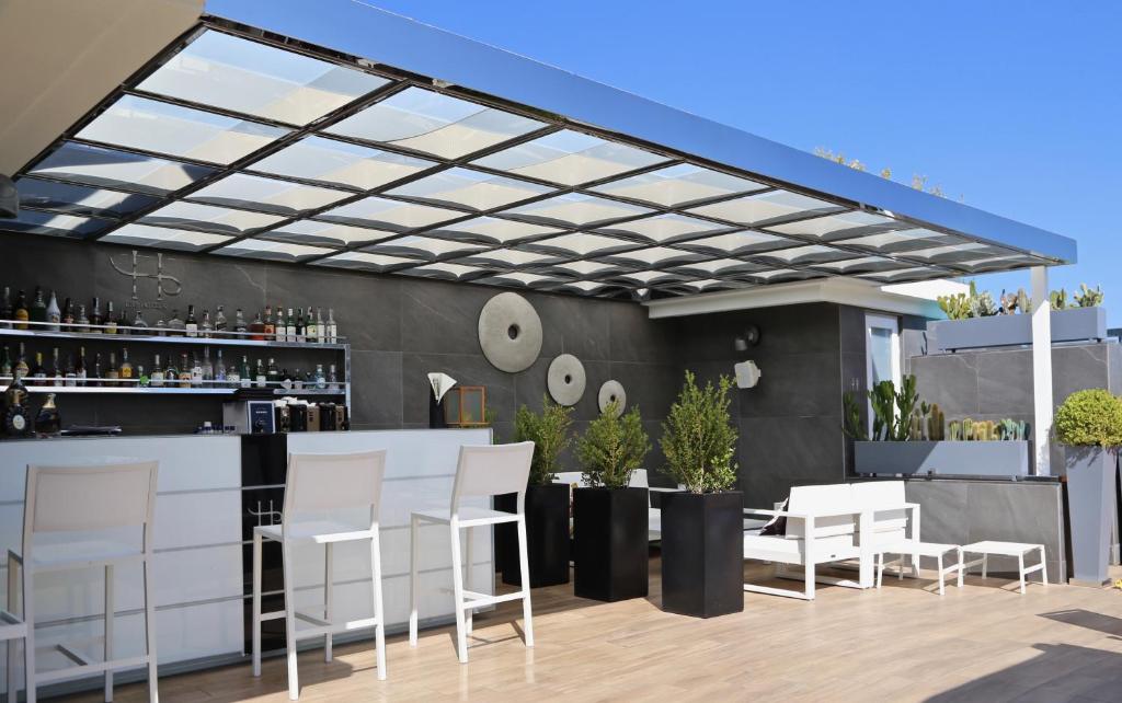 a patio with white chairs and a bar at LHP Napoli Palace & SPA in Naples