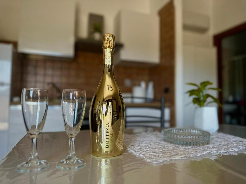 eine Flasche Champagner und zwei Gläser auf dem Tisch in der Unterkunft Valentino Bed And Breakfast in Capodrise