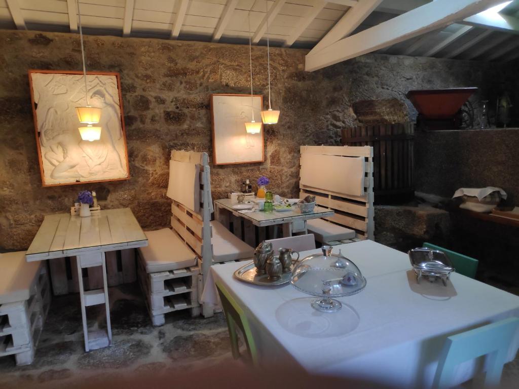 a room with tables and chairs in a restaurant at Casas da Quinta da Cancela in Balugães