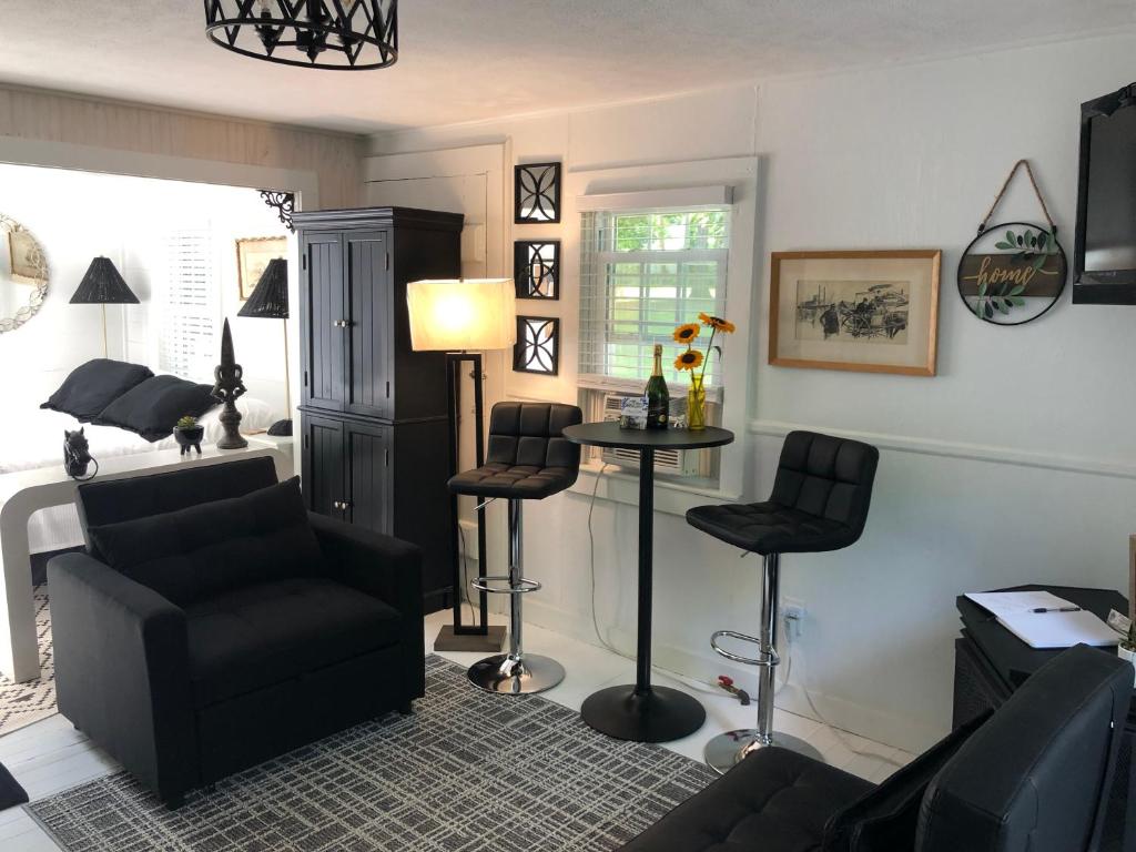 ein Wohnzimmer mit einem Sofa, einem Tisch und Stühlen in der Unterkunft 18 Vine Inn & Carriage House in Hammondsport