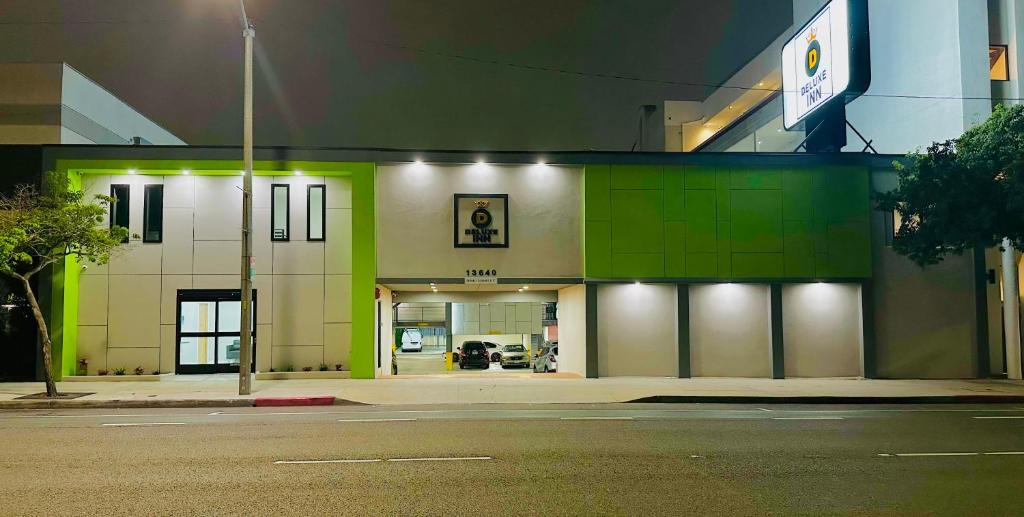 un edificio con verde y blanco en una calle en Deluxe Inn Hawthorne/ LAX en Hawthorne