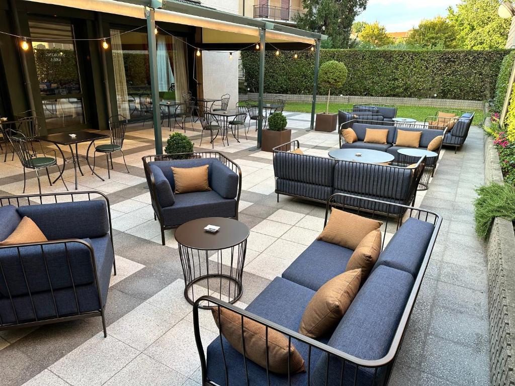 d'une terrasse avec des canapés, des tables et des chaises. dans l'établissement The Regency Sure Hotel Collection by Best Western, à Lissone