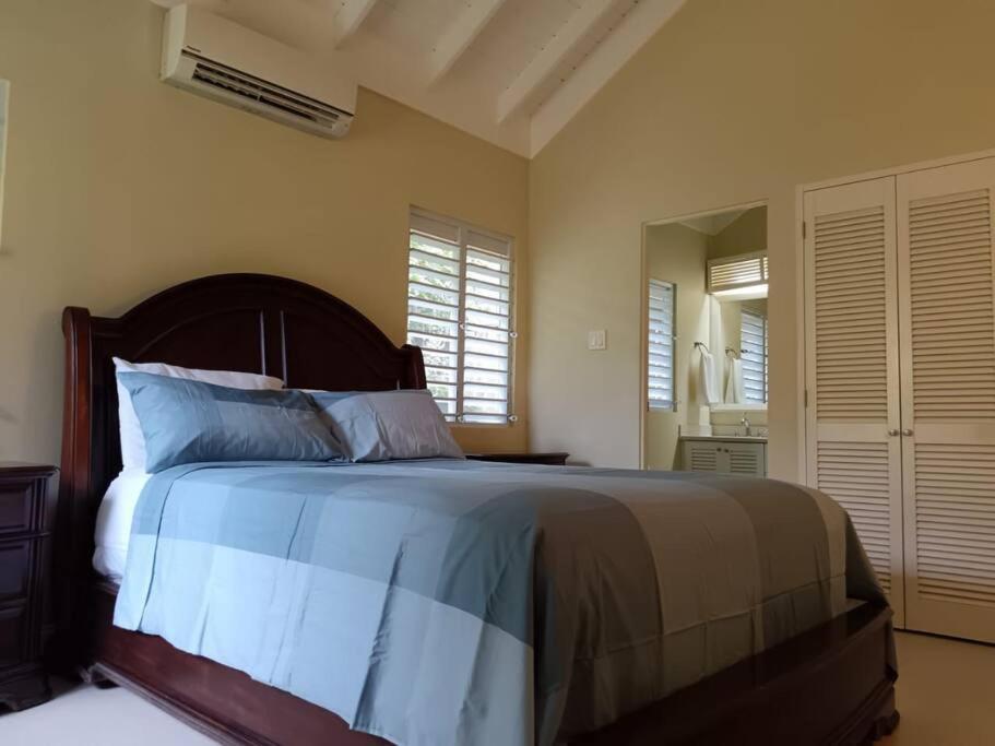a bedroom with a large bed with blue and white sheets at Mahoe Villa @ Richmond Estate in Richmond