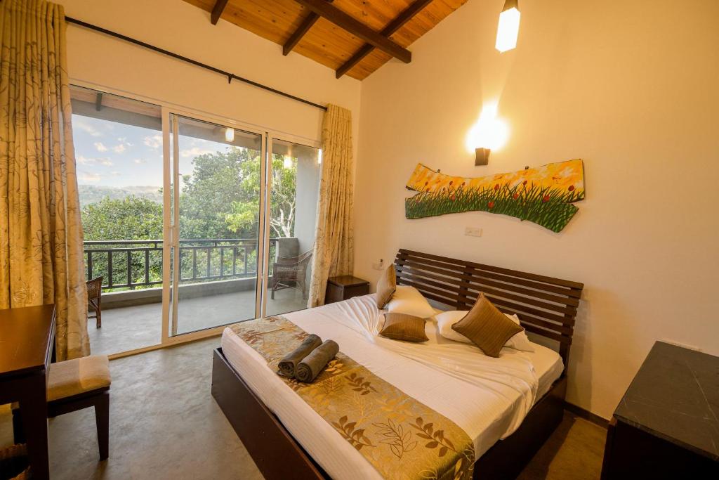 a bedroom with a bed and a large window at The Hills By Blue Fox in Kandy
