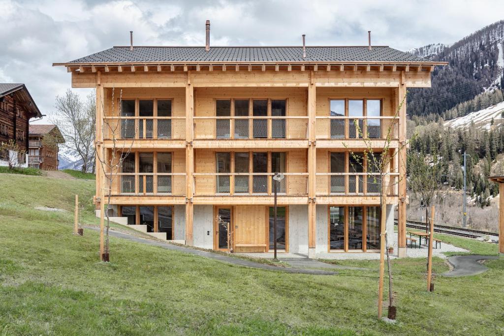 een huis in aanbouw op een heuvel met gras bij Berglodge Goms (Hotel) in Münster