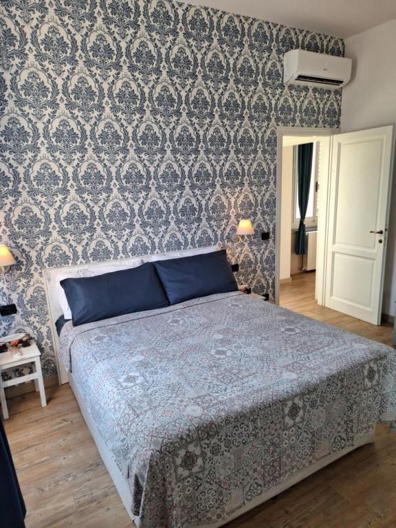 - une chambre avec un lit et un mur recouvert de papier peint dans l'établissement Frida Firenze, à Florence