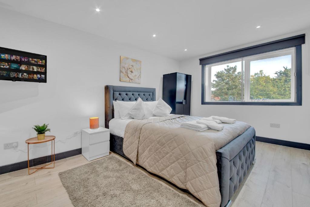 a bedroom with a large bed and a window at Captivating 1-Bed Studio in Feltham in Feltham