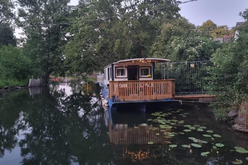 una casa flotante en un río con muelle en Au fils de l'eau en Estrasburgo