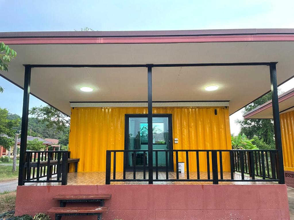 a building with a yellow curtain in front of it at The Monday ที่พักราคาถูก ใกล้หาดแหลมแม่พิมพ์ in Klaeng