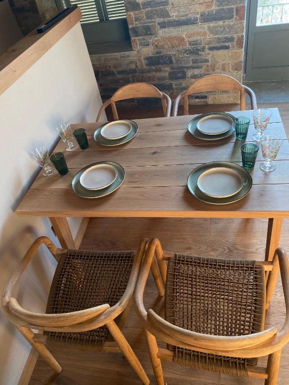 a wooden table with two chairs and a wooden table with plates at EJ Boutique Suites in Milina