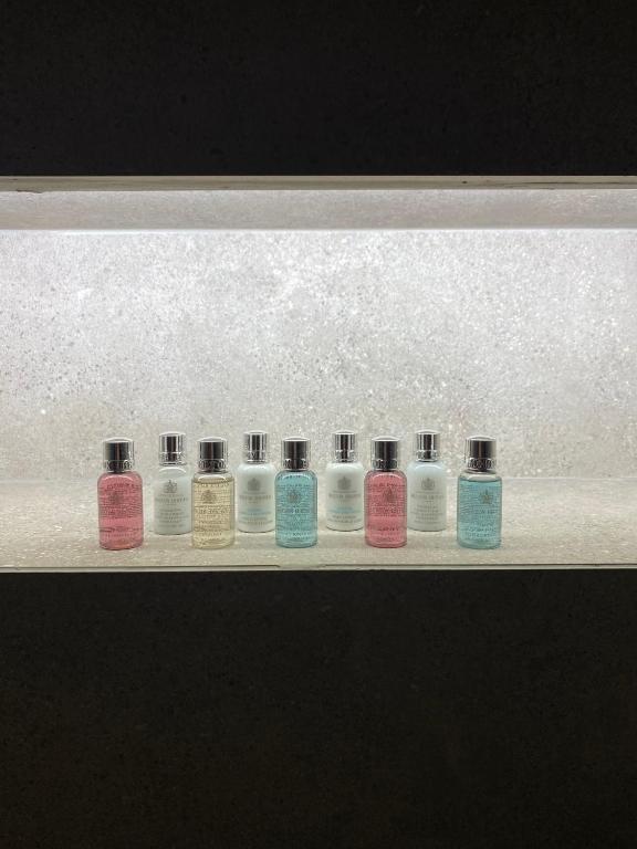 a row of different colored bottles on a shelf at EJ Boutique Suites in Milina
