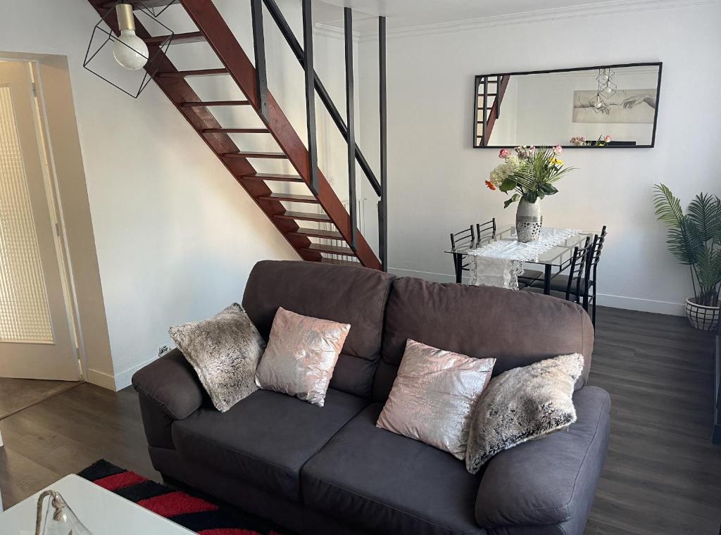 sala de estar con sofá y escalera en Appartement spacieux proche de paris, en Carrières-sur-Seine