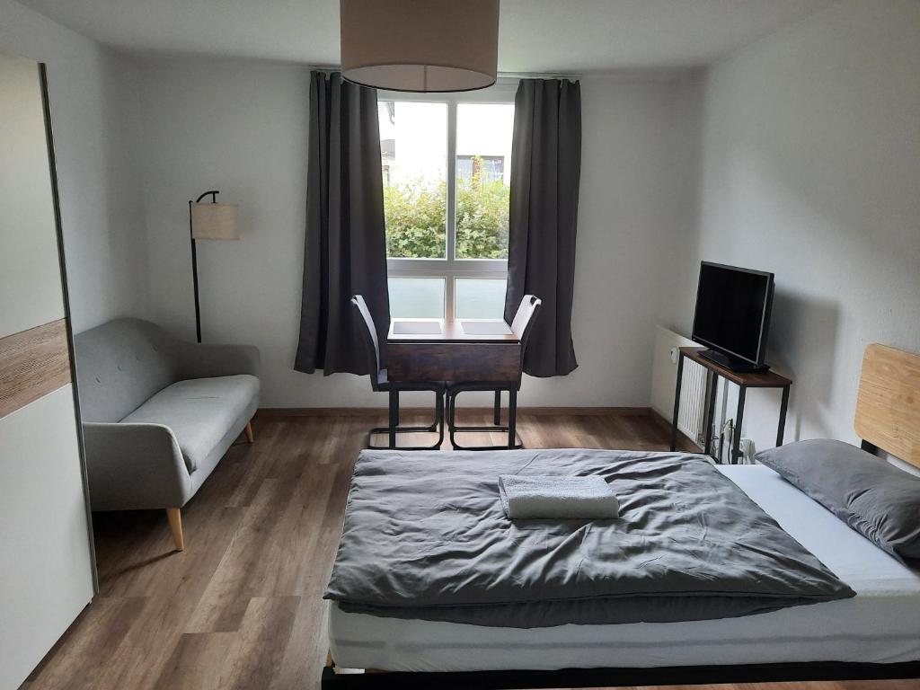 a bedroom with a bed and a chair and a window at Apartment in Bielefeld Heepen in Bielefeld