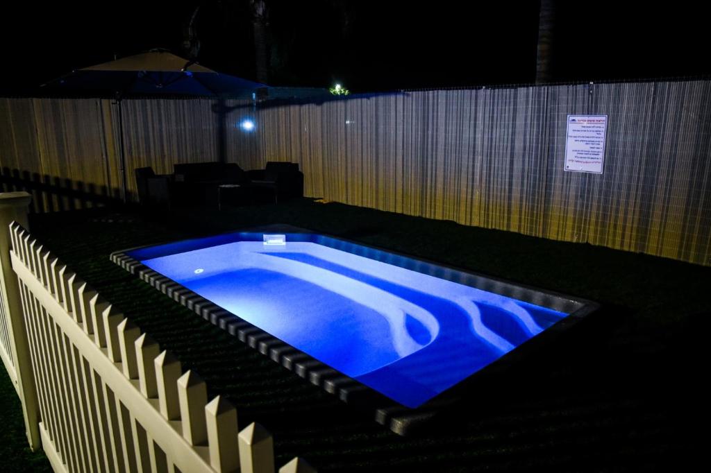 una piscina con iluminación azul en una habitación oscura en סוויט ריזורט בגורן en H̱osen