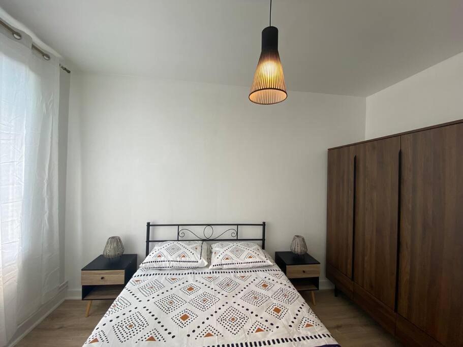 una camera con letto e lampadario di Bel appartement centre ville de Vierzon a Vierzon