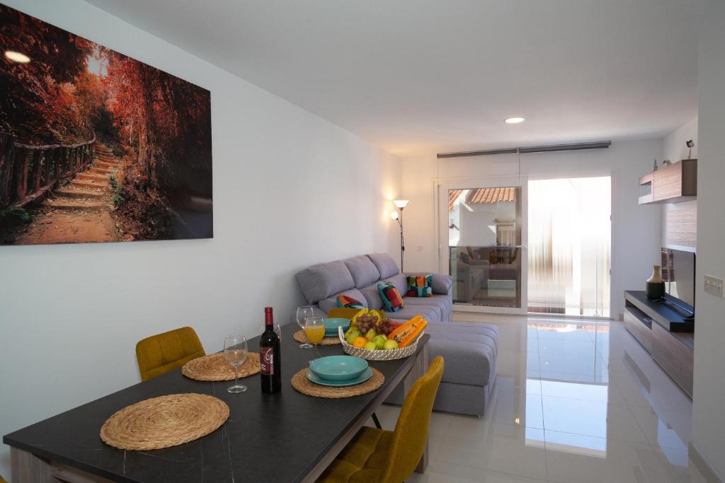 a kitchen and living room with a table and a couch at Casa Brillante in Playa de San Juan