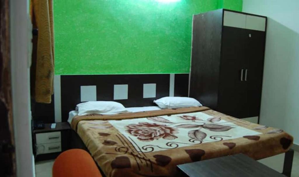 a bedroom with a bed and a green wall at Goroomgo Viren Holiday Home Agra in Agra