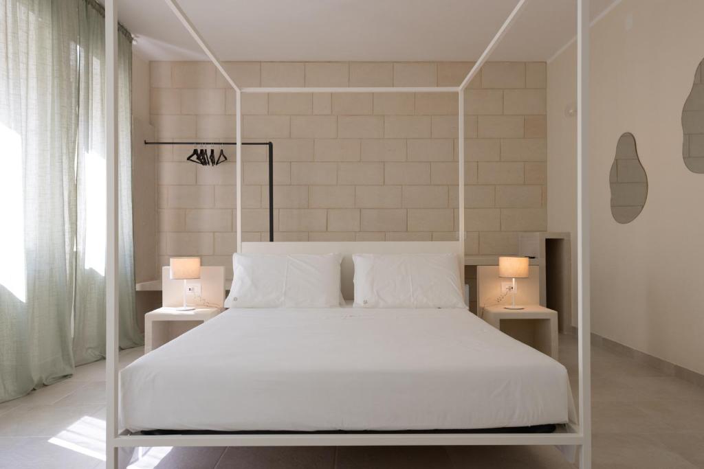 a bedroom with a white bed with two lamps at Oronti Accommodations in Lecce