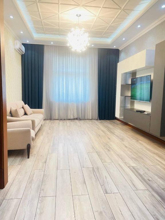 sala de estar amplia con sofá y TV en Center luxury Apartment is situated in Tashkent., en Yakkasaray