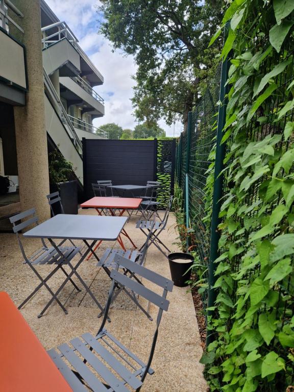 a patio with tables and chairs next to a fence at Premiere Classe Quimper in Quimper