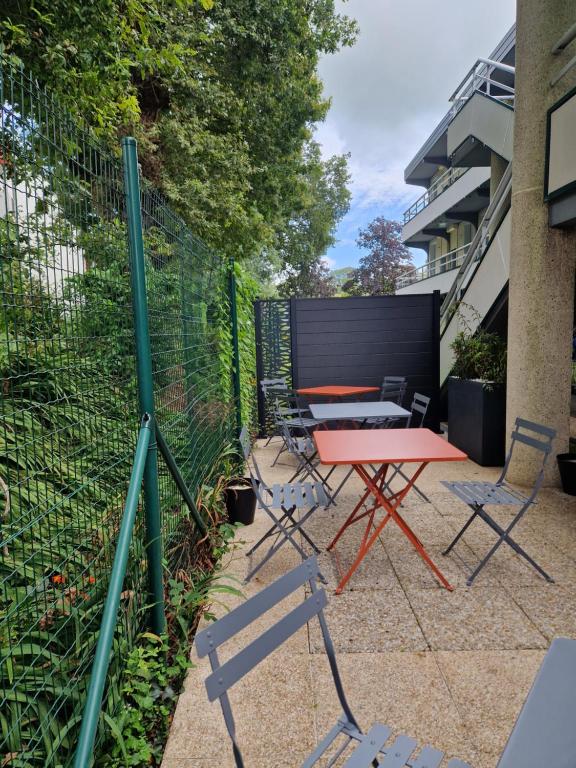 a patio with a table and chairs and a fence at Premiere Classe Quimper in Quimper