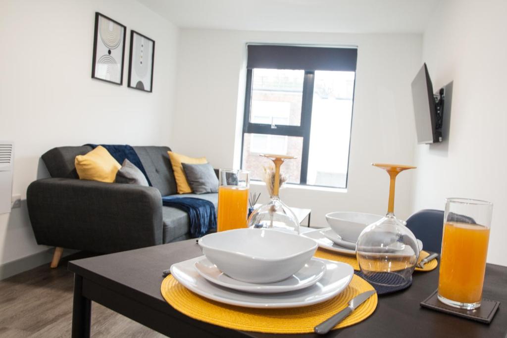 a living room with a table with plates and orange juice at Luxurious City Center 1 BR Vibrant Liverpool in Liverpool