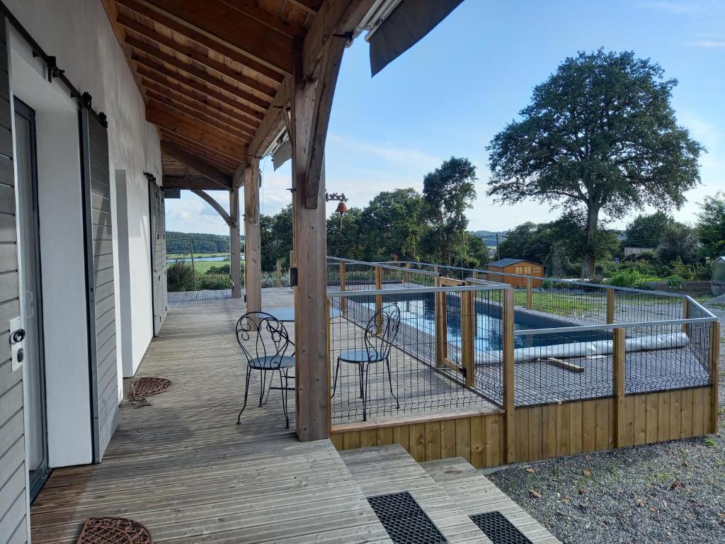 un porche con 2 sillas y una piscina en Studio Kerwood Sud Morbihan vue sur la Vilaine en Béganne