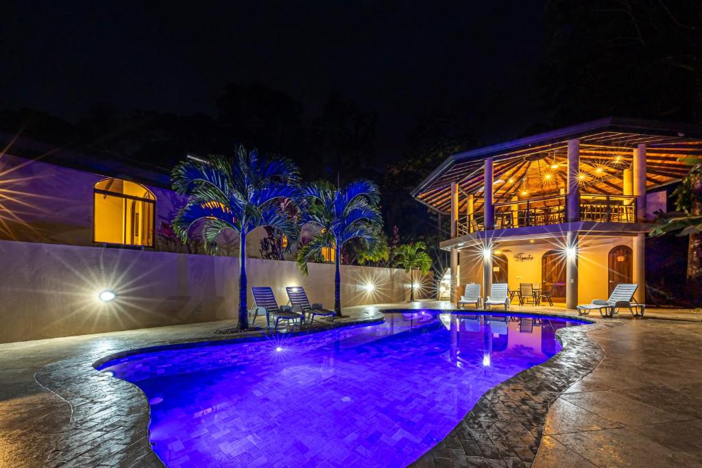 una piscina por la noche con luces moradas en Las Palomas Villas Of Uvita, en Uvita