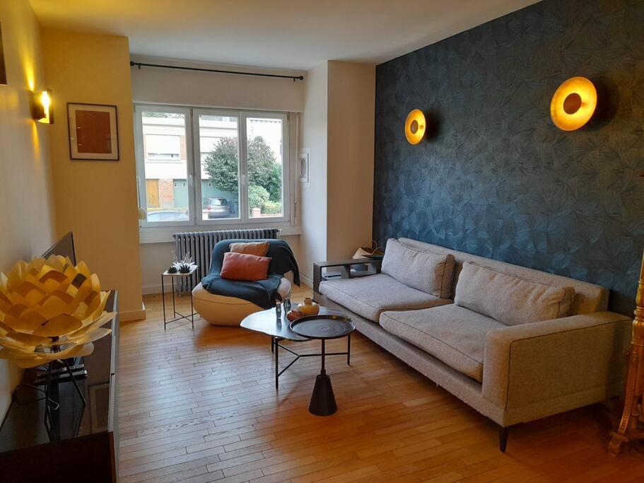 ein Wohnzimmer mit einem Sofa und einem Tisch in der Unterkunft Grd maison 6 Couchages, 25 mn du stade en métro in Lambersart