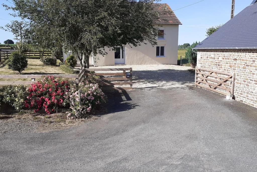 une maison avec une clôture, un portail et des fleurs dans l'établissement Maison calme individuelle proche du Mont st Michel, à Saint-Aubin-de-Terregatte