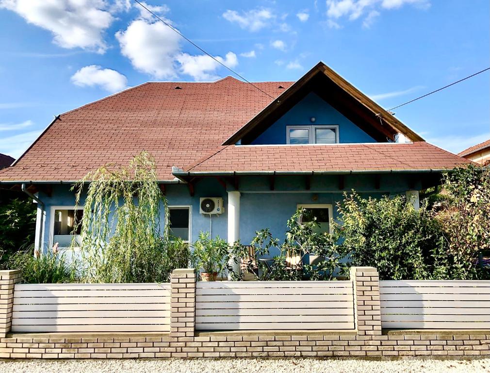 a house with a brick fence in front of it at Casa Galliera - Apartment in Keszthely