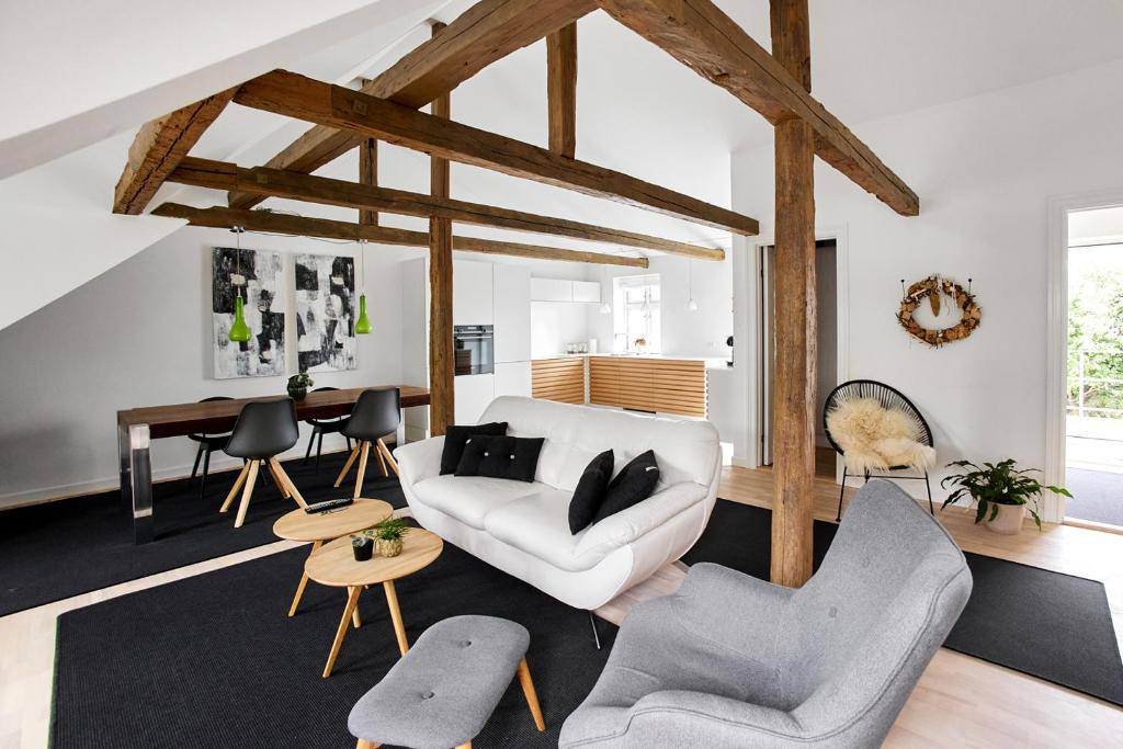 a living room with a white couch and chairs at Charmerende lejlighed in Fredericia